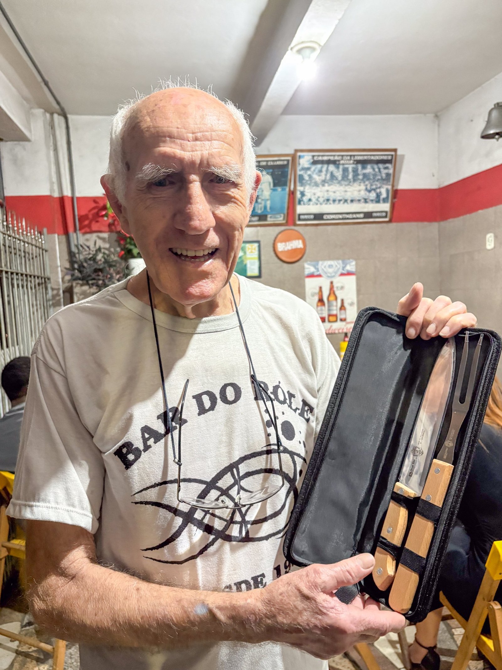 Paciente da Oral Sin Guaratinguetá sorrindo e segurando um estojo